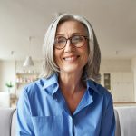 Smiling mature older woman looking at camera, webcam headshot.